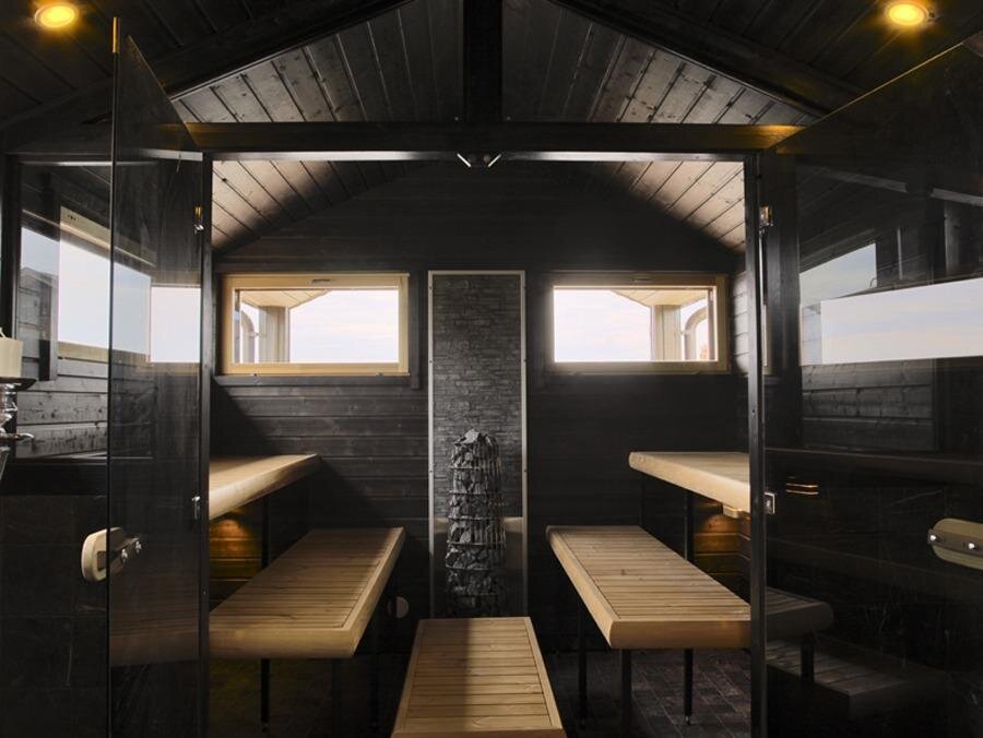 Tyylikkään tumma sauna mökin pihalla