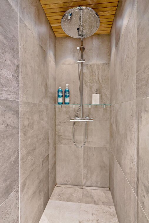 Suuri sadesuihku ja betonimaiset laatat kylpyhuoneessa