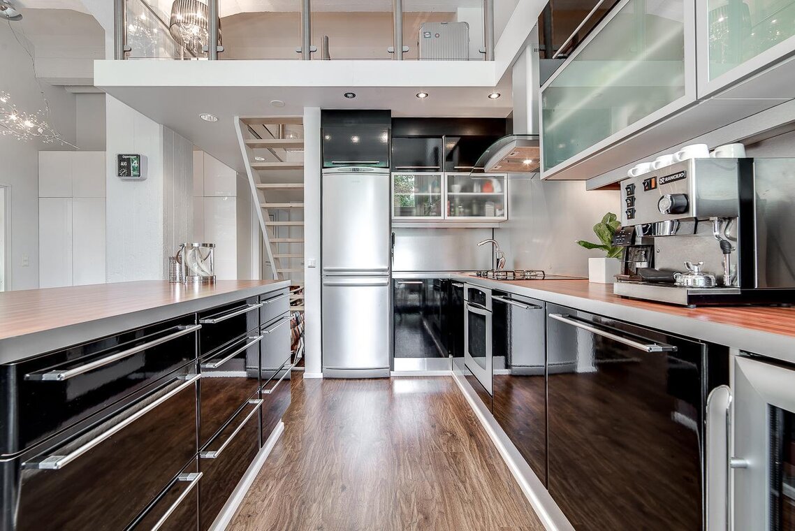 Loft-asunnon moderni musta keittiö