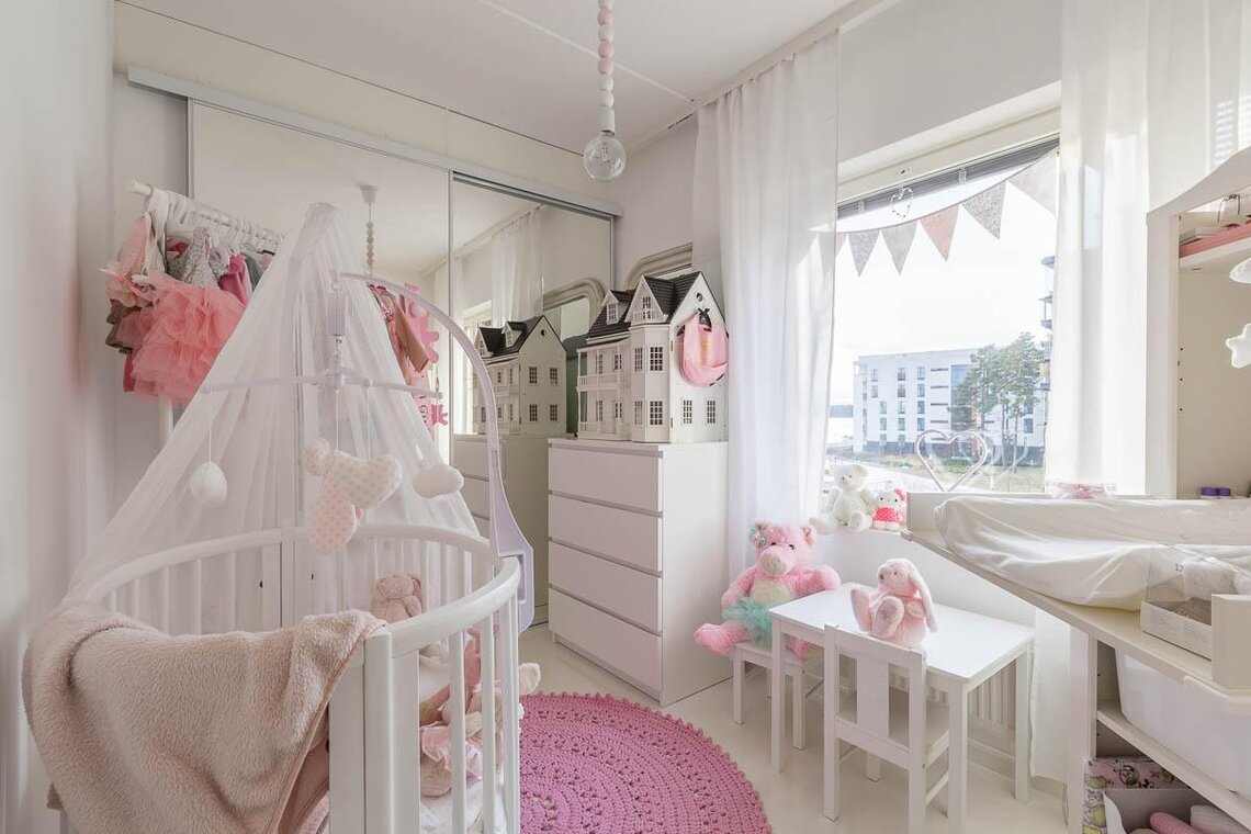 Suloinen vauvan huone vaaleanpunaisine yksityiskohtineen