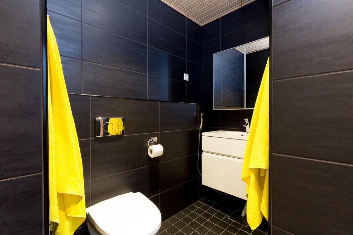 Musta moderni wc ja ripaus keltaista