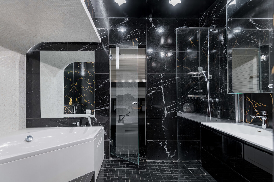 Ylellistä mustaa marmoria kylpyhuoneen seinissä