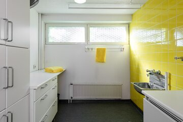 Pirteän keltaiset kaakelit kodinhoitohuoneessa