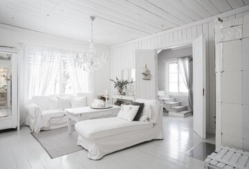 Valkoista maalaisromanttista unelmaa hirsitalon olohuoneessa