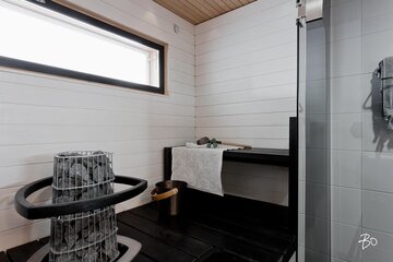 Mustavalkoisen saunan ikkunasta voi ihailla merinäkymiä