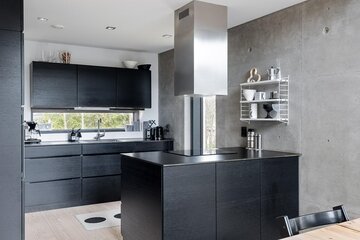 Musta moderni keittiö betoniseinineen