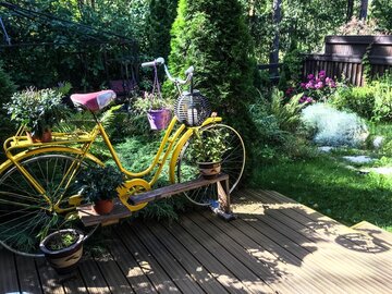 Vanha polkupyörä toimii ihastuttavana kukkatelineenä pihalla