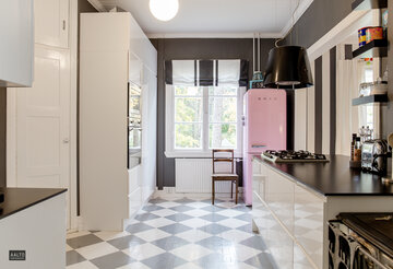 Smegin vaaleanpunainen jääkaappi-pakastin ja mustavalkoinen shakkiruutulattia keittiössä