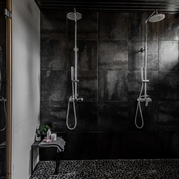 Luonnonkivinen laattalattia mustassa kylpyhuoneessa
