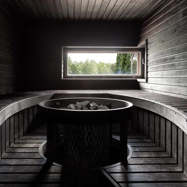 Musta sauna kaarevilla lauteilla