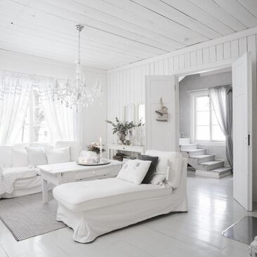Valkoista maalaisromanttista unelmaa hirsitalon olohuoneessa