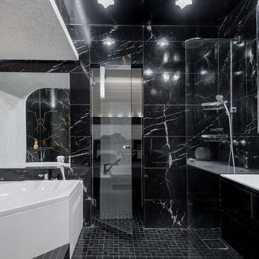Ylellistä mustaa marmoria kylpyhuoneen seinissä